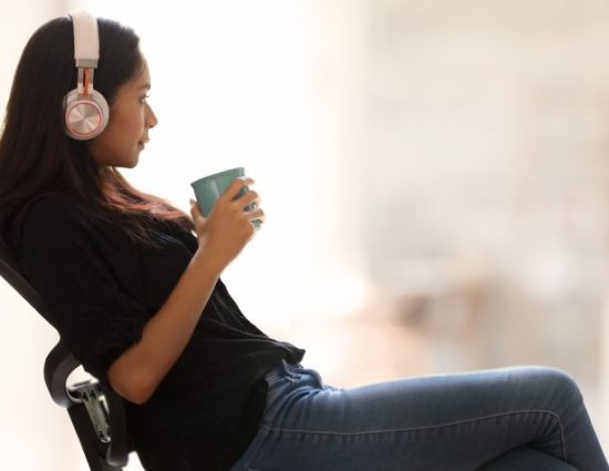 Woman at work wearing headphones looking relaxed