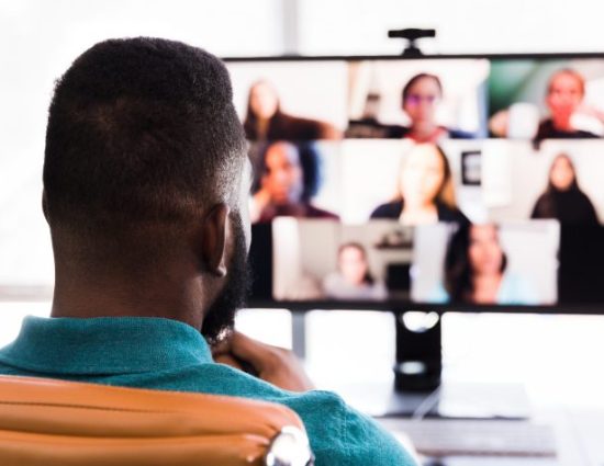 A mid adult businessman meets with his colleagues during a video conference.