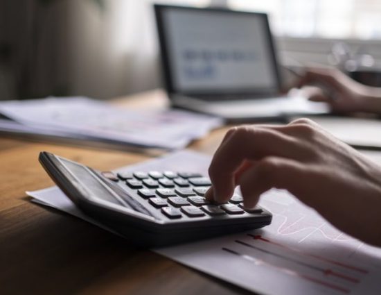 Business man using calculator with laptop