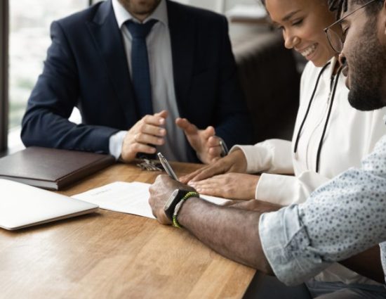 Confirming deal. Close up of happy african husband wife signing up contract in presence of lawyer financial advisor. consultation