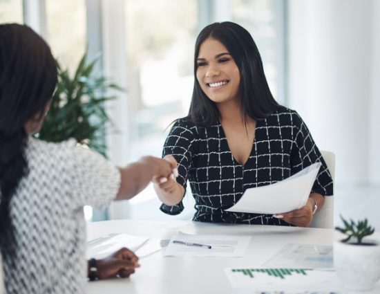 Shot of two young businesswomen shaking hands in a modern office