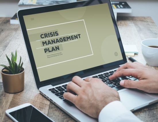 Person working on a crisis management plan on a laptop