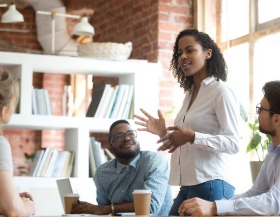 Ambitious female employee speaking at meeting