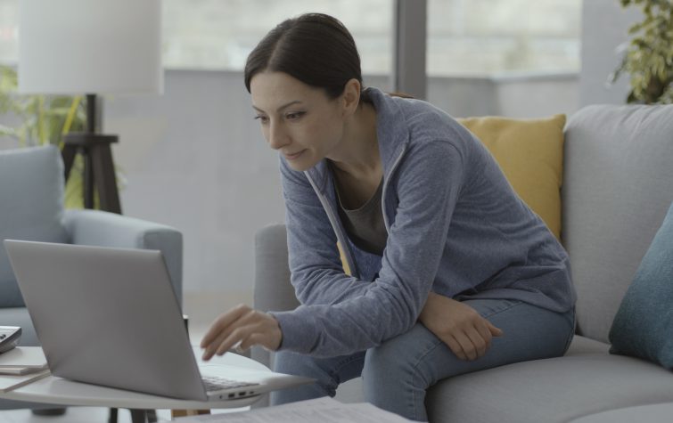 Woman sitting on the couch and working with her laptop