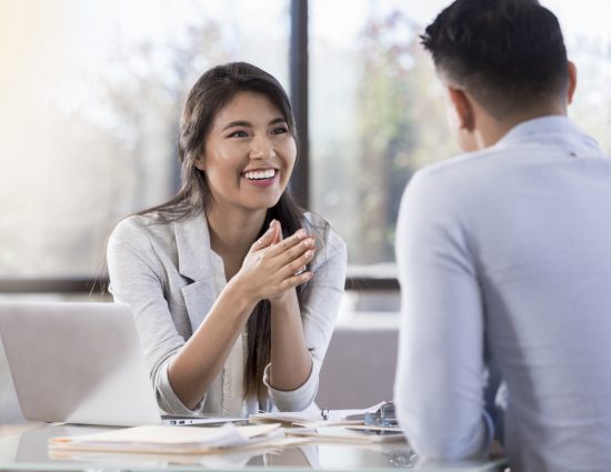 Smiling businesswoman meets with a male colleague.